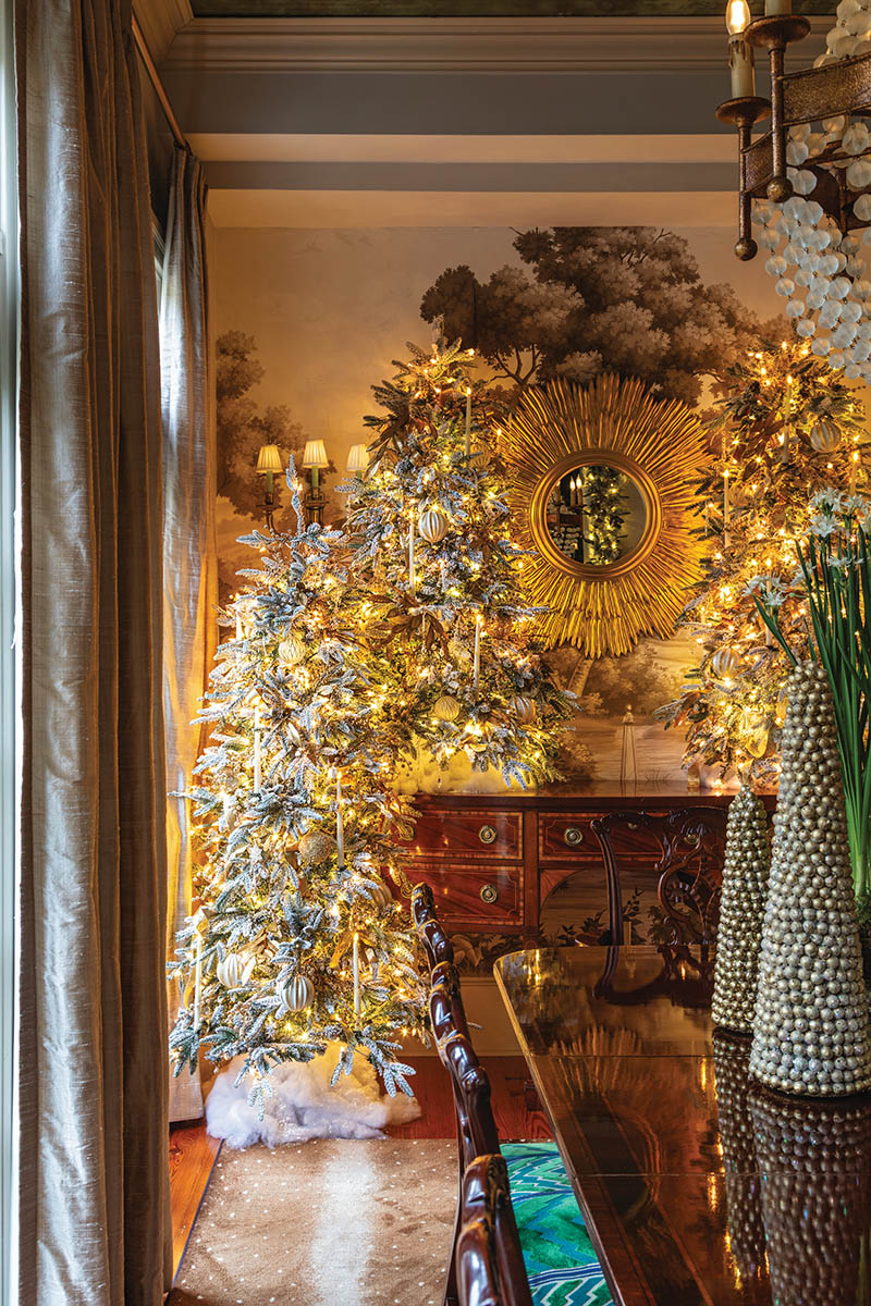 It’s all about layering: For the dining room’s winter wonderland, John adds dimension and volume to each tree and strand of garland through abundant candles, ornaments, and ribbon. But he also considers how complementary design elements—here, a collection of metallic tabletop trees, elegant potted paper-whites, and fluffy faux snow—will fully bring the space to life. After all, more is more during the holiday season.