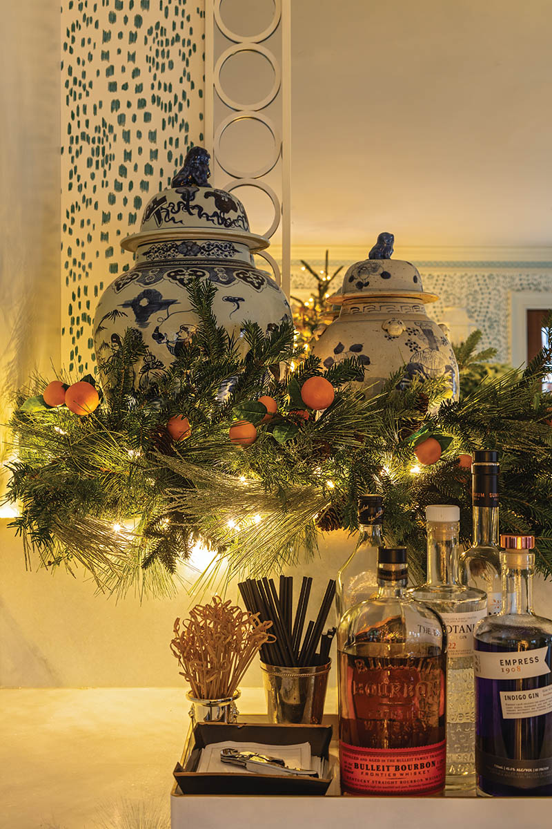 The garland stretching along the pool house’s built-in wet bar features real trimmings for a whiff of fresh pine, while petite faux citrus inserts provide a pop of color.