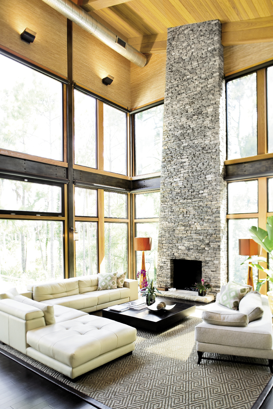 Chris opted to keep the home’s sturdy steel framing exposed in the lofty great  room, which features a 27-foot stacked  stone