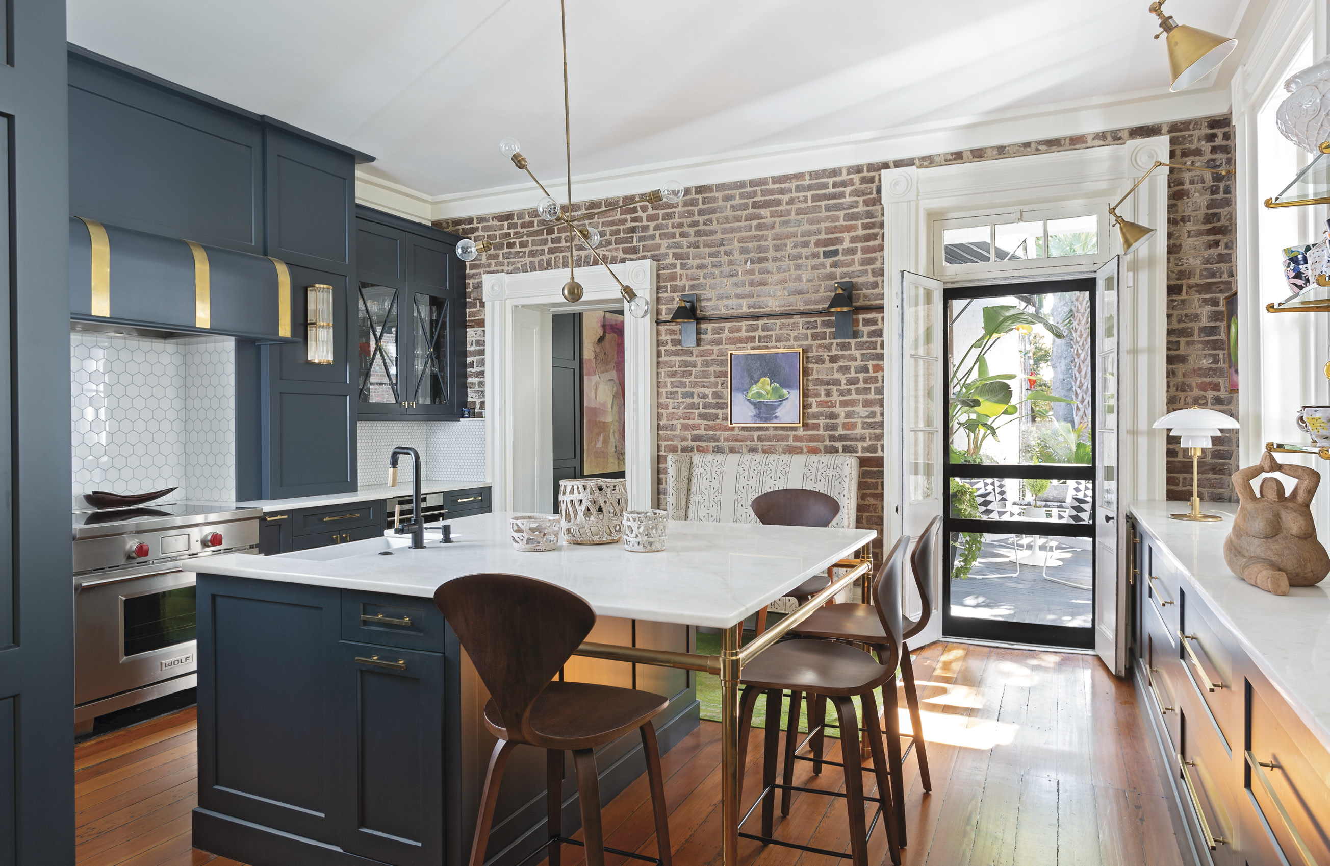 Kitchen Confidence: Turning the formal dining room into a kitchen was the biggest challenge of the renovation. A 19th-century fireplace made way for a Wolf induction stove; plaster was removed to reveal the home’s original brick; and John’s Island cabinet maker Robert Paige worked some magic to craft plenty of storage for this family of adventurous cooks.