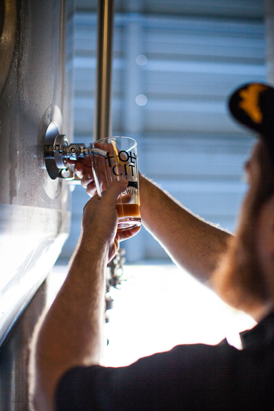 Chris Brown takes a sample from a fermentation tank.