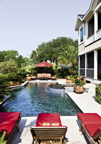 Splash of Color: While interior tones are cool and calm,  outside is beachy bold and bright. The pool is a favorite family hangout with two shallow ends for the kids. Ample porches (open on the second floor and screened below) capitalize on beachfront breezes.
