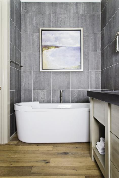 Spa Treatment: Gray slate tiles run floor to ceiling and offer a serene backdrop for deep spa tubs in both master baths.