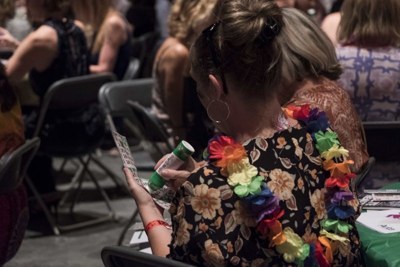 Guests carefully check their bingo cards, looking for the winning numbers.