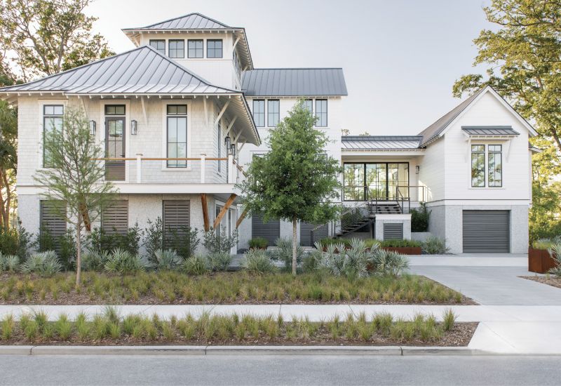 New Perspective: An empty marshfront lot in a new neighborhood on the just-developed Captain’s Island gave the Cuoco family the perfect opportunity to start over, embrace their passions, and create a space for the next stage of their lives. The resulting home eschews the traditional architecture and lush green lawns of its nearby neighbors on Daniel Island. Its modular design is highlighted by a tower, floating staircase, and glass entryway nestled in a landscape of native grasses, shrubs, and trees.