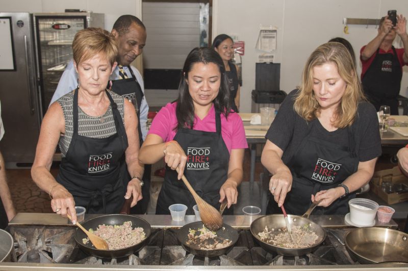Gerri Greenwood, Vanessa White, and Amanda Samson saute ground pork for the lettuce wraps.