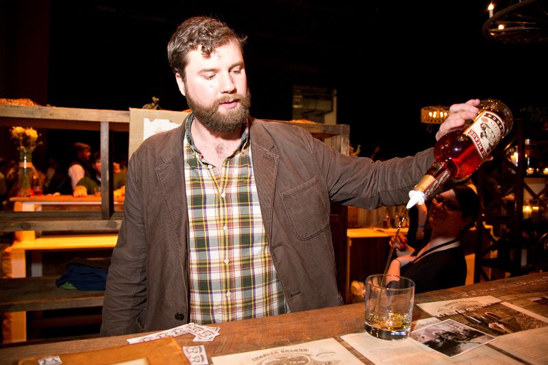 Charlie Nelson pours a glass of bourbon.